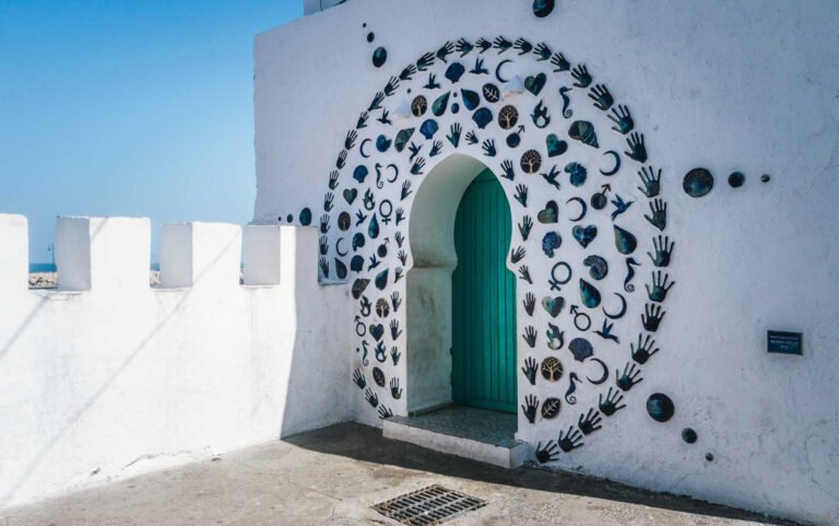 Painted mural around a green door in the Asilah medina