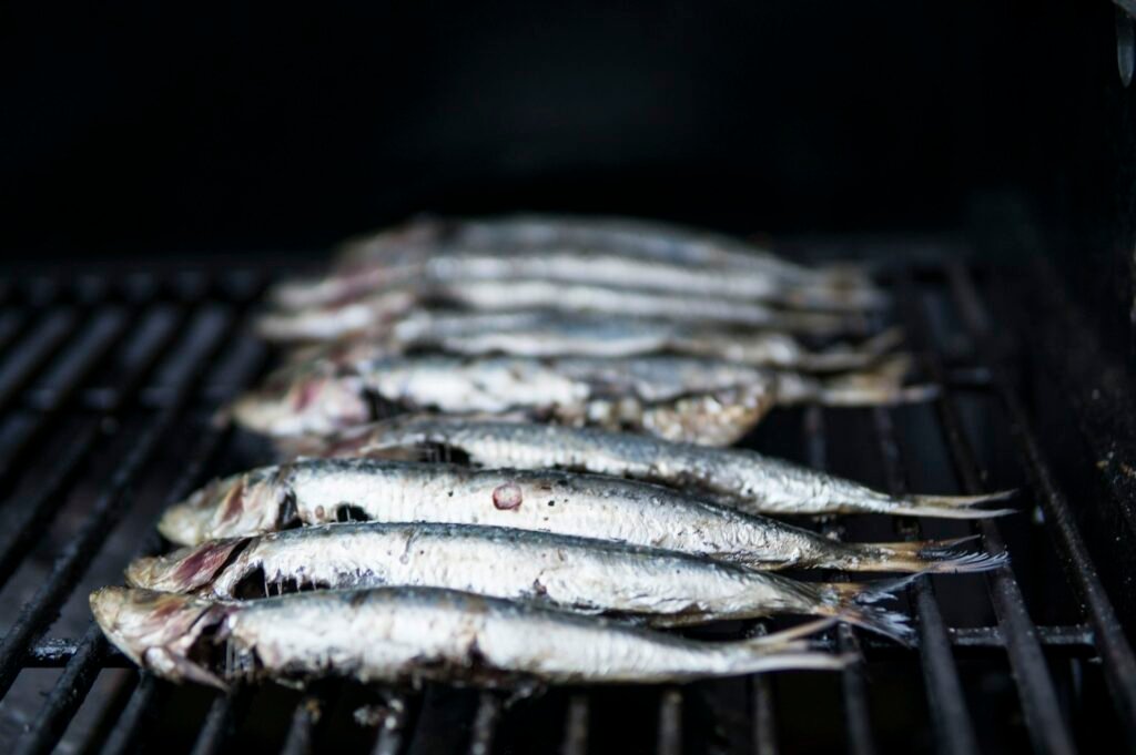 Sardines sur un grill à charbon, le classique poisson grillé sur la plage