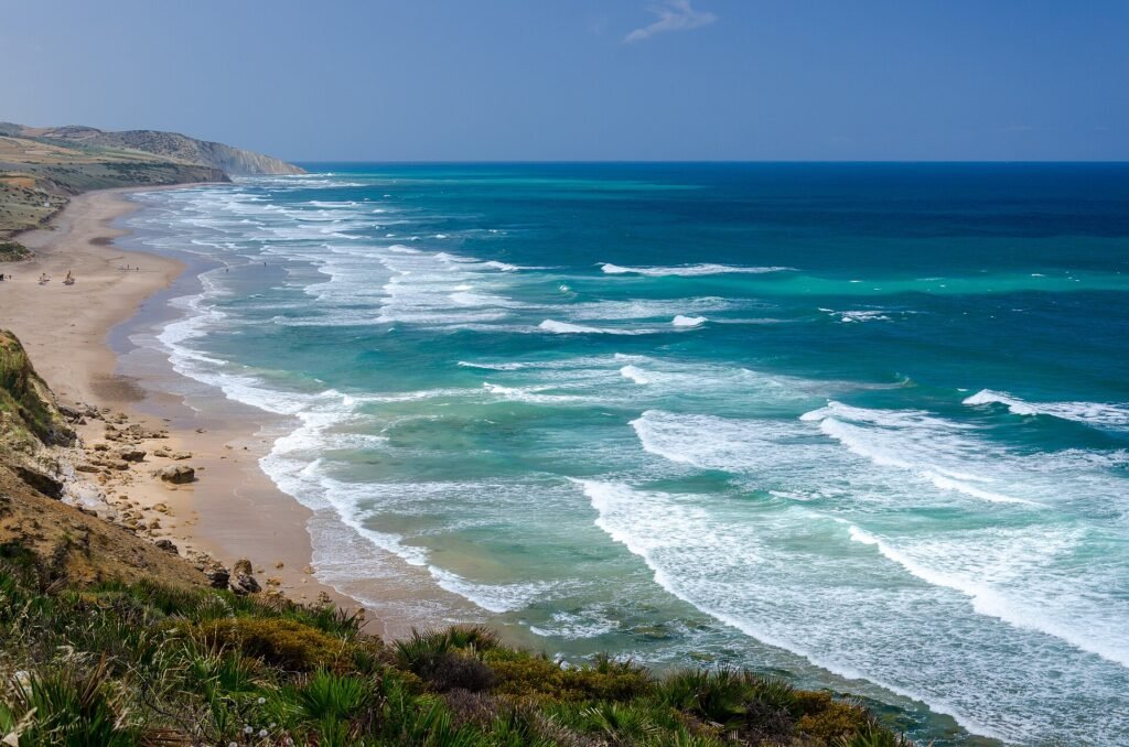 A wide beach and turquoise Atlantic waves on the coast near Asilah