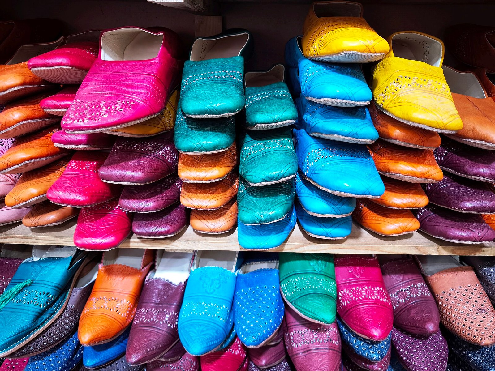 Colourful Moroccan babouches piled on shelves
