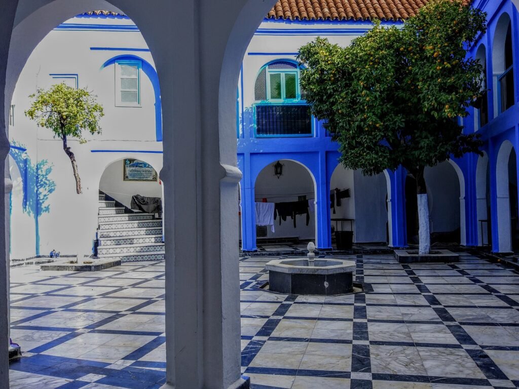A blue courtyard with an orange tree in the old town of Chefchaouen