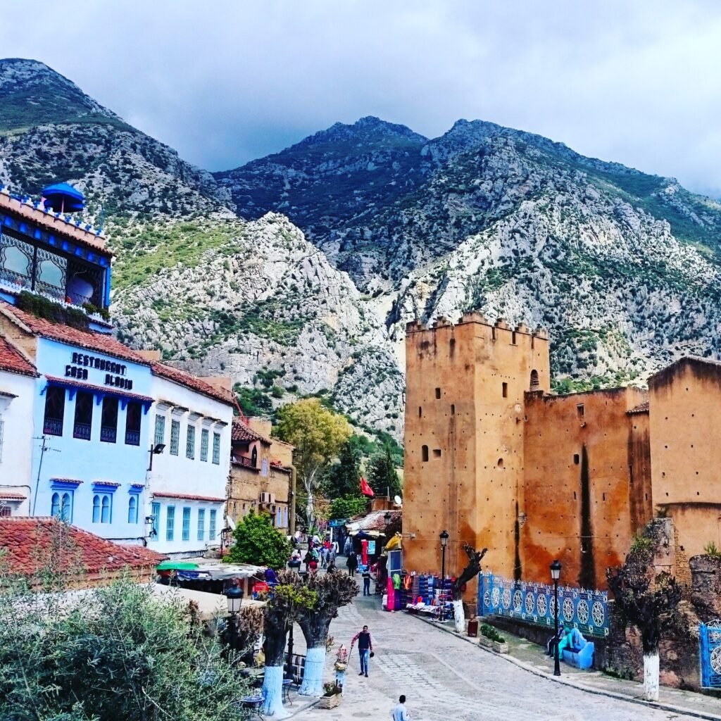 The red walls of the kasbah of Chefchaouen with the blue town and the Rif mountains behind