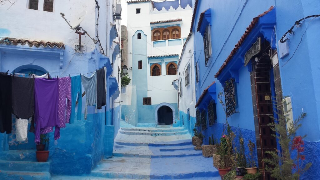 A blue alley with washing hanging between the houses of Chefchaouen