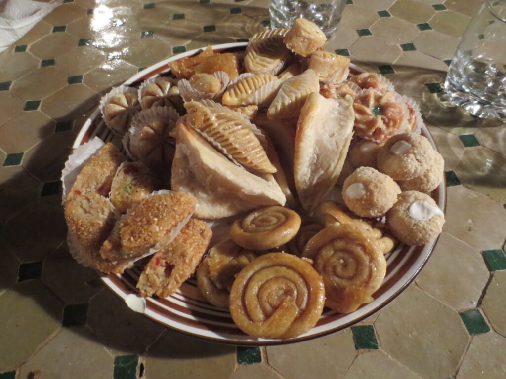 A plate of Moroccan pastries and biscuits on a tiled table