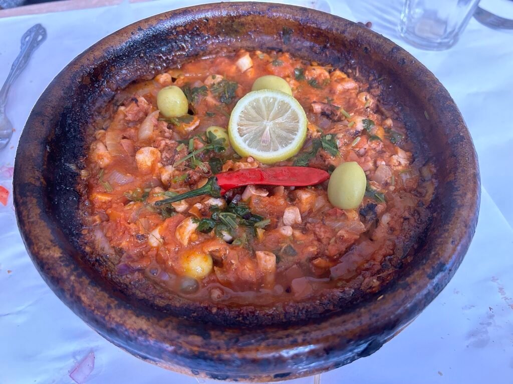 A seafood tagine with lemon in a clay dish, an example of Tangier seafood