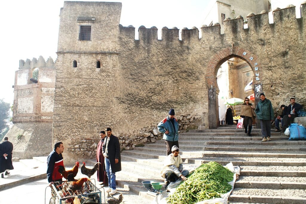Vendors and passers-by on the steps below the old gate of Bab el-Okla in Tetouan