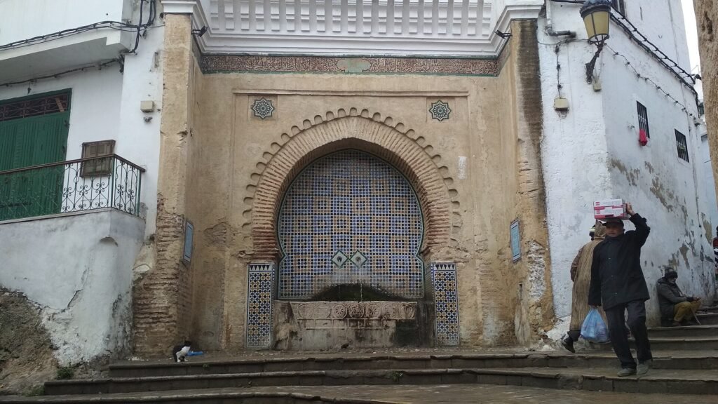 A tiled fountain under a horseshoe arch at a corner of the medina of Tetouan